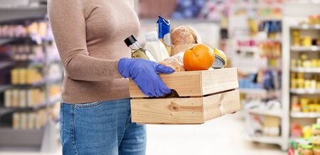 woman in gloves with food in wooden boxの写真素材