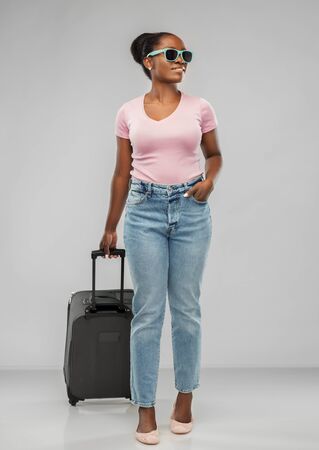 happy african woman in sunglasses with travel bagの写真素材