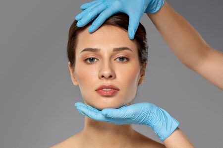 beautiful young woman face and hand in gloves