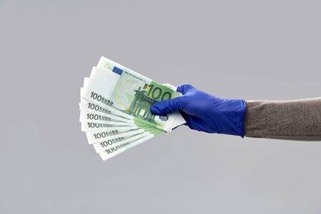 close up of hand in medical glove with money