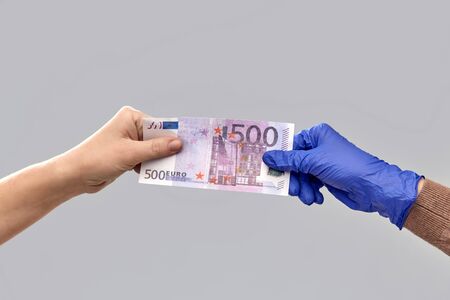 close up of hand in medical glove giving moneyの写真素材