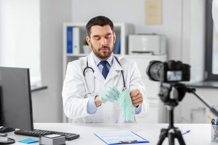 male doctor with gloves recording video blogの写真素材