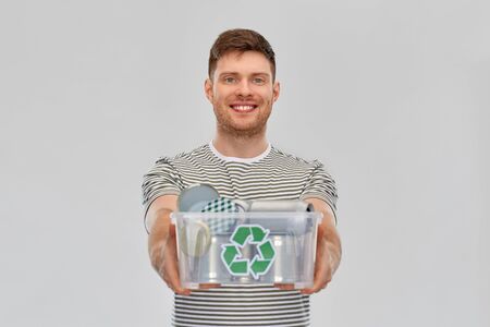 smiling young man sorting metallic wasteの写真素材