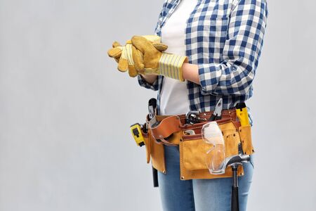 woman or builder with gloves and working toolsの写真素材