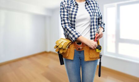 woman or builder with working tools on beltの写真素材