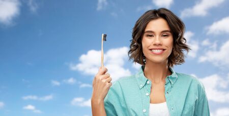 smiling young woman with wooden toothbrush