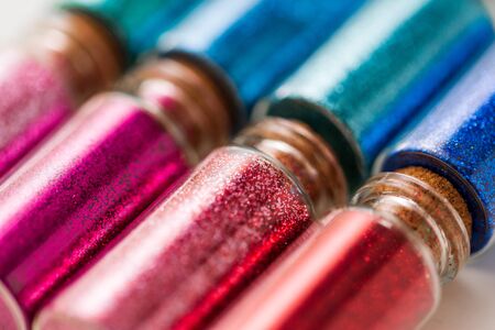 set of different glitters in small glass bottles