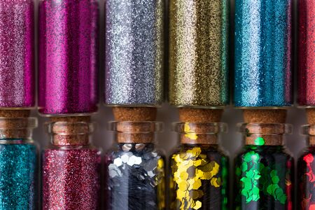 set of different glitters in small glass bottles