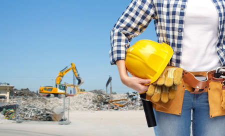 construction business, job and people concept - close up of woman or builder with helmet and working...