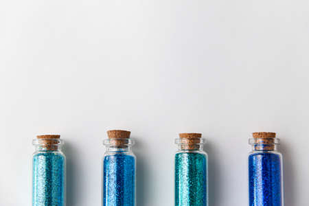 blue glitters in bottles over white backgroundの写真素材