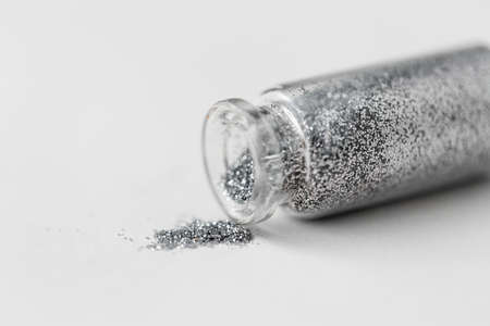 silver glitters poured from small glass bottleの写真素材