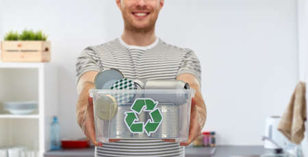 smiling young man sorting metallic wasteの写真素材