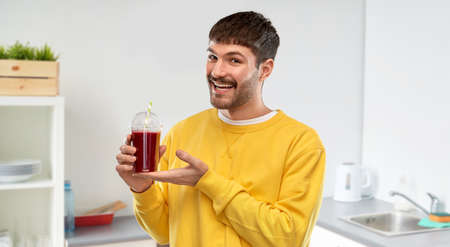 happy man with tomato juice in takeaway cup