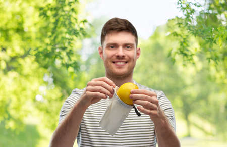 smiling man with lemon in reusable canvas bagの写真素材