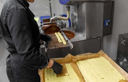 worker processing candies at confectionery shop