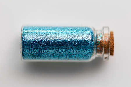 blue glitters in bottle over white backgroundの写真素材
