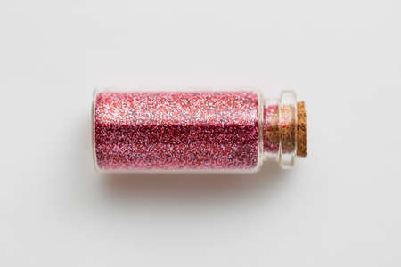 red glitters in bottle over white backgroundの写真素材