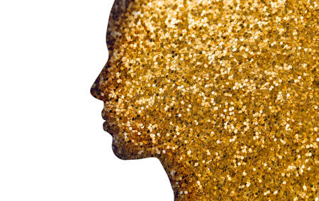 beauty and luxury concept - silhouette of beautiful woman face of golden glitters or sequins on white backgroundの写真素材