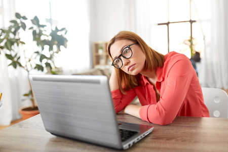 bored woman with laptop working at home office