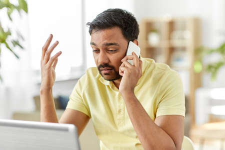 man calling on smartphone at home office