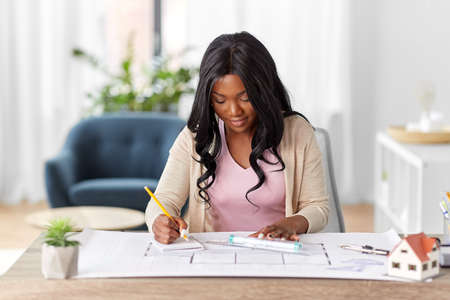 female architect with house model and blueprint