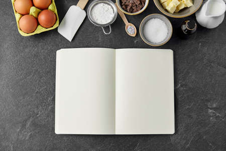 recipe book and cooking ingredients on tableの写真素材