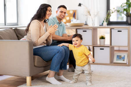 happy family with child sitting on sofa at homeの写真素材