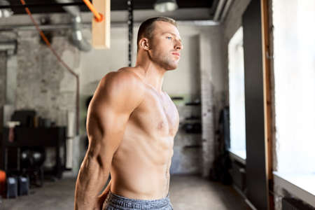 young man with bare torso in gymの写真素材