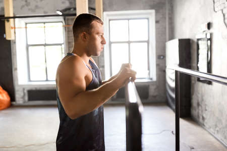 young man at parallel bars in gym