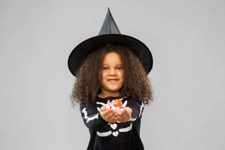 girl with candies trick-or-treating on halloweenの写真素材