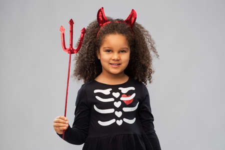 girl with trident and devils horns on halloween