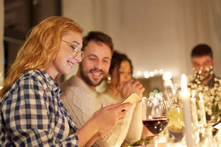 friends with cellphone having dinner party at home
