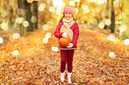happy girl with pumpkin at autumn park