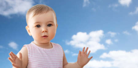portrait of little baby girl over blue sky