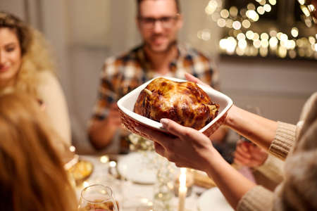 happy friends having christmas dinner at homeの写真素材