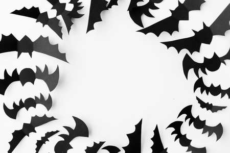 flock of black paper bats over white background
