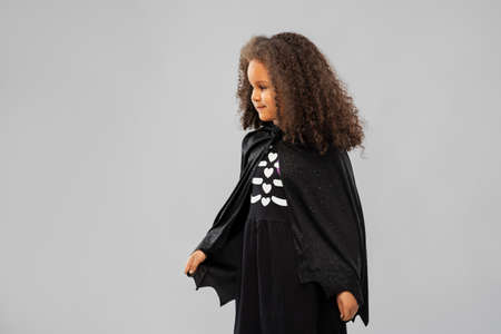 girl in costume of dracula with cape on halloweenの写真素材