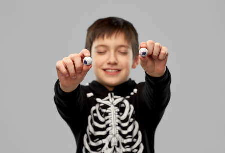 boy in halloween costume with eyeball candiesの写真素材