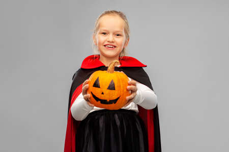 girl in halloween costume of dracula with pumpkinの写真素材