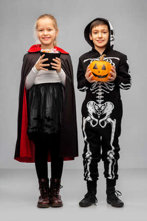 happy children in halloween costumes with candiesの写真素材