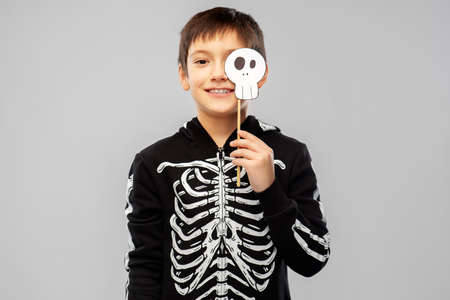 boy in halloween costume of skeleton with scull