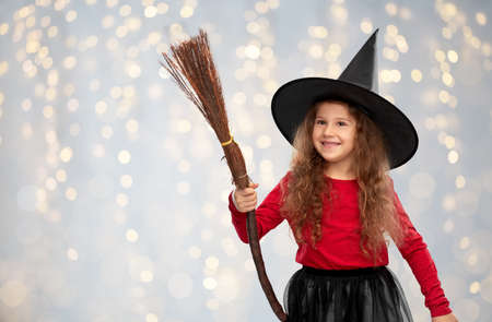 girl in black witch hat with broom on halloweenの写真素材