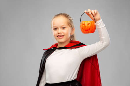 girl in halloween costume of dracula with pumpkinの写真素材