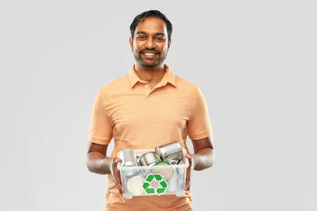 smiling young indian man sorting metallic waste