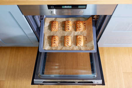 baking tray with jam pies in oven at home kitchen