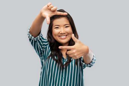 happy asian woman making frame of fingers