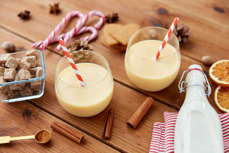 glasses of eggnog, ingredients and spices on woodの写真素材