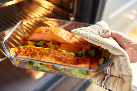 woman cooking food in oven at home kitchenの写真素材