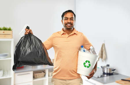 smiling indian man sorting paper and plastic wasteの写真素材