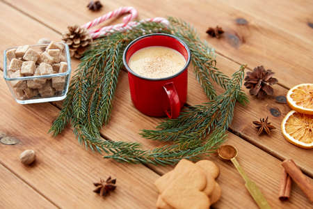 cup of eggnog, fir branches, gingerbread and sugar